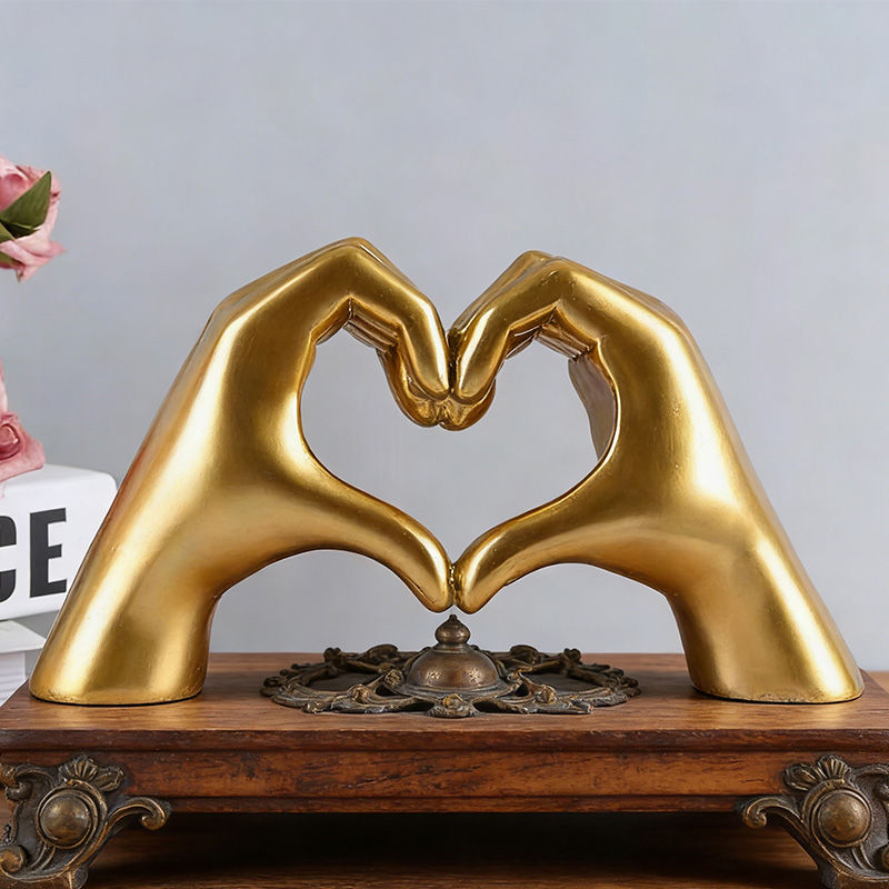 Hand aus goldenem Harz in Herzform